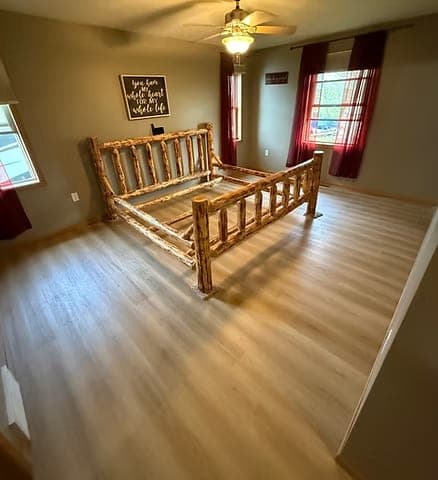Light wood-look vinyl and laminate floor in a bedroom with a log bed
