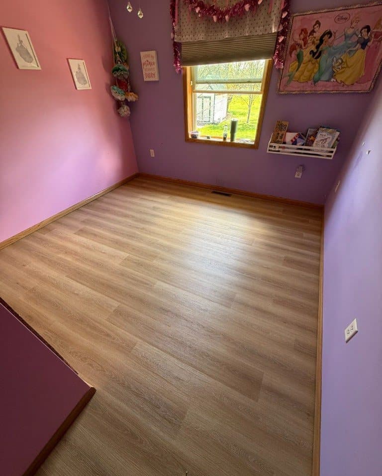 Light oak-look vinyl plank in a bedroom with pink and purple walls